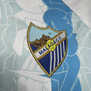 Málaga CF 2024/2025 - Camiseta titular Málaga CF - Hummel Málaga CF - Segunda División - Diseño moderno - Detalles únicos - Málaga - Azul - Blanco - Rojo - Azulejos tradicionales - Gola redonda - Escudo del Málaga CF - Logo de Hummel - Tradición malagueña - Innovación de Hummel - Tecnologías innovadoras - Confort - Rendimiento.